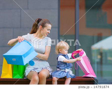 Mother and baby looking into shopping bag 14791874