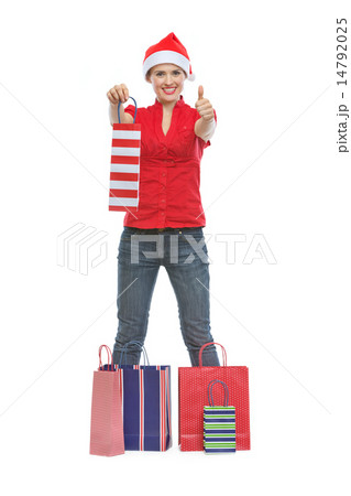 Happy young woman in Christmas hat standing among shopping bags 14792025