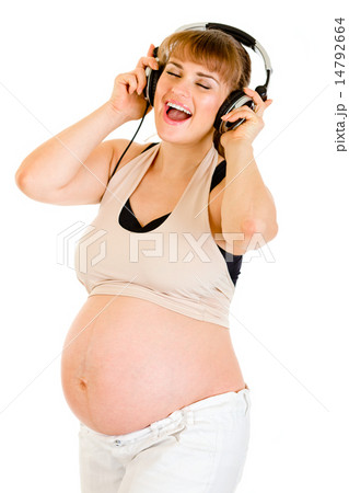 Happy pregnant woman listening music in headphones . Happy pregnant woman listening music in headphones . 14792664