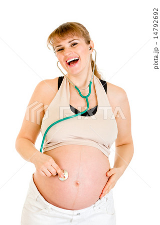 Laughing pregnant woman holding stethoscope on her belly. Laughing pregnant woman holding stethoscope on her belly. 14792692