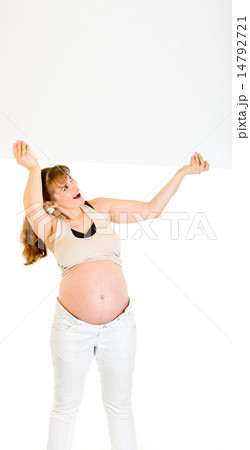 Smiling pregnant woman holding blank billboard over her head. 14792721