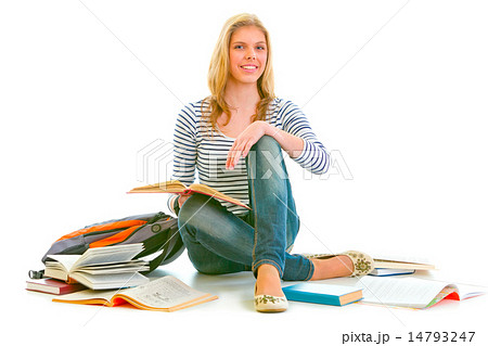 Cheerful teen girl sitting on floor among schoolbooks 14793247