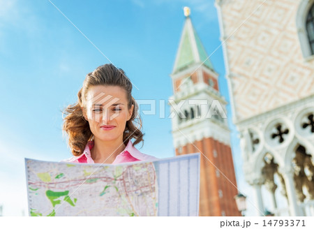 Portrait of young woman looking at map against campanile di san 14793371