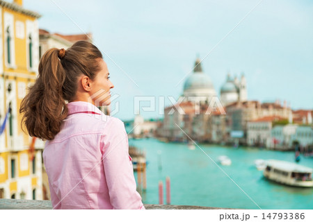 Young woman looking into distance while standing on bridge with Young woman looking into distance while standing on bridge with 14793386