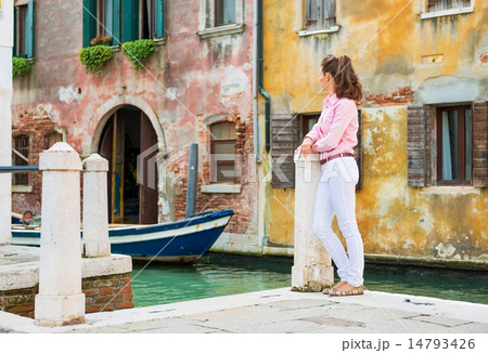 Young woman standing on street in venice, italy and looking into 14793426