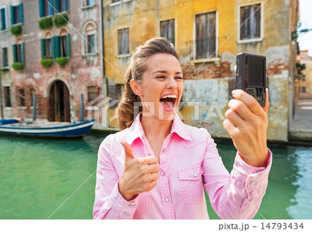 Happy young woman showing thumbs up and making selfie in venice, Happy young woman showing thumbs up and making selfie in venice, 14793434