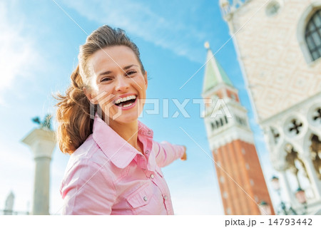 Happy young woman pointing on campanile di san marco in venice, 14793442