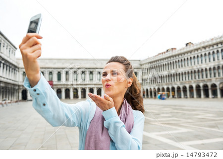 Young woman blowing kiss and making selfie on piazza san marco i Young woman blowing kiss and making selfie on piazza san marco i 14793472