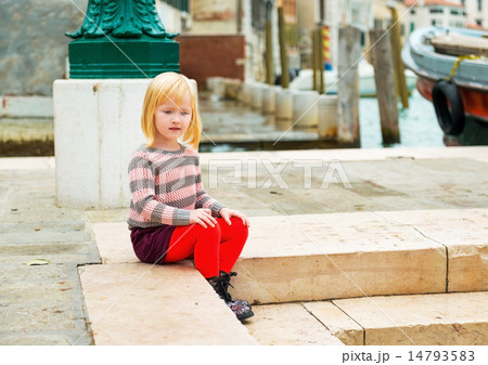 Baby girl sitting on embankment in venice, italy 14793583