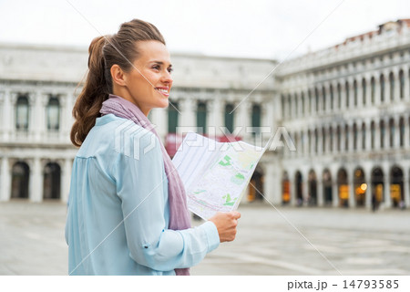 Happy young woman with map on piazza san marco in venice, italy 14793585