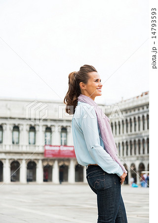 Happy young woman standing on piazza san marco in venice, italy 14793593