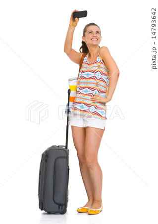 Happy young tourist woman with wheel bag taking self photo Happy young tourist woman with wheel bag taking self photo 14793642