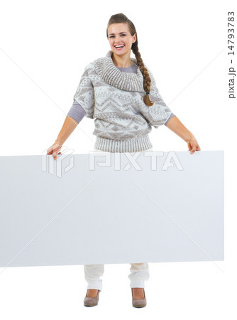 Full length portrait of smiling young woman in sweater holding b 14793783