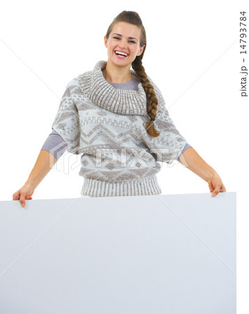 Smiling woman in sweater holding blank billboard 14793784