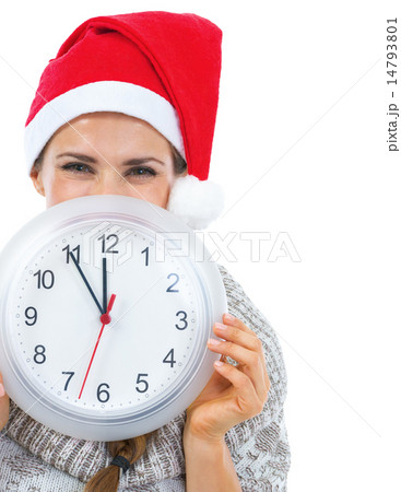 Smiling young woman in sweater and christmas hat hiding behind c 14793801