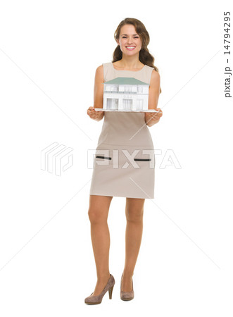 Happy woman homeowner showing scale model of house 14794295