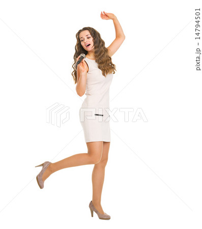 Full length portrait of happy young woman singing in microphone Full length portrait of happy young woman singing in microphone 14794501