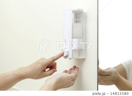 woman pressing the liquid soap to her hand 14813380