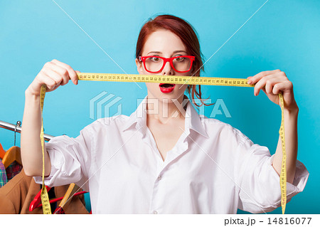 Surprised young redhead designer with metric 14816077