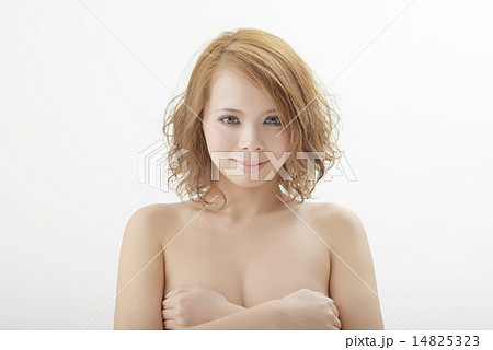 バストを抑えてポーズする女性モデルの写真素材