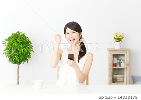 スマートフォンを持ってガッツポーズする女性 14838178