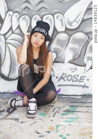 Asian woman resting on a penny skateboard. 14839125