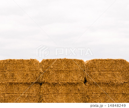 Six stacked yellow hay bales on overcast sky 14848249