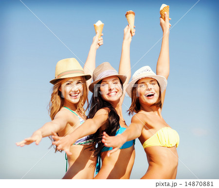 girls in bikinis with ice cream on the beach 14870881