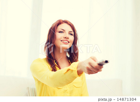 smiling teenage girl with tv remote control smiling teenage girl with tv remote control 14871304