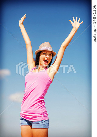girl with hands up on the beach 14871306