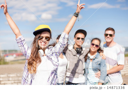 teenage girl with headphones and friends outside teenage girl with headphones and friends outside 14871336