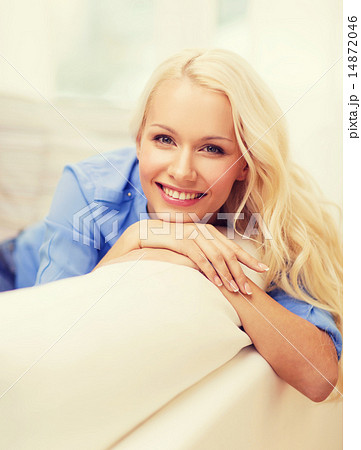 smiling young woman lying on sofa at home 14872046