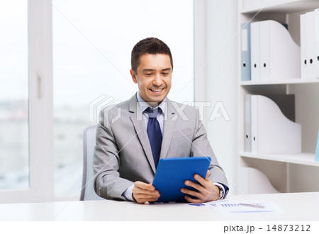 smiling businessman with tablet pc in office 14873212