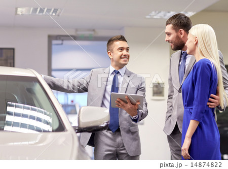 happy couple with car dealer in auto show or salon 14874822