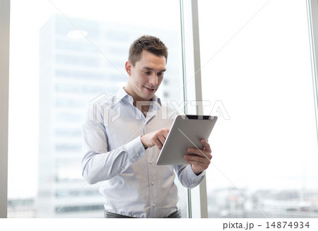 smiling businessman with tablet pc in office 14874934