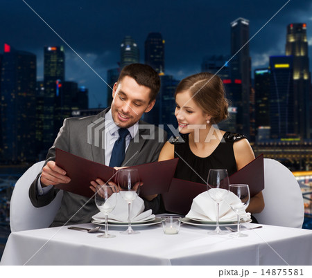 smiling couple with menus at restaurant smiling couple with menus at restaurant 14875581