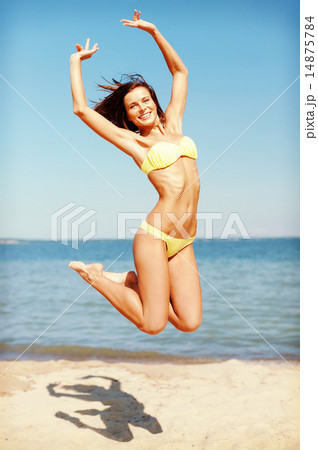 woman in bikini jumping on the beach woman in bikini jumping on the beach 14875784