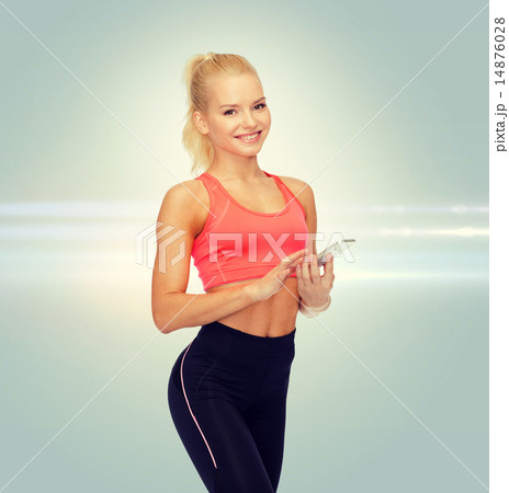 smiling sporty woman with smartphone 14876028