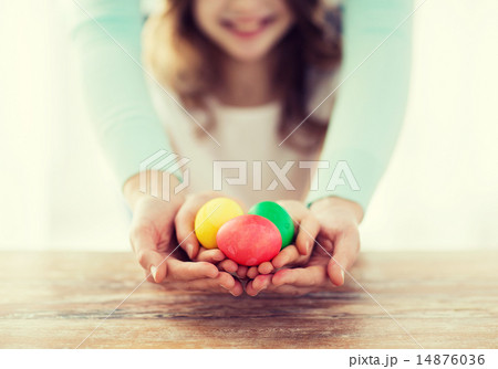close up of girl and mother holding colored eggs close up of girl and mother holding colored eggs 14876036