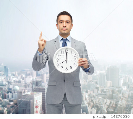 businessman in suit holding clock with 8 o'clock businessman in suit holding clock with 8 o'clock 14876050