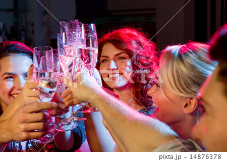 smiling friends with glasses of champagne in club smiling friends with glasses of champagne in club 14876378