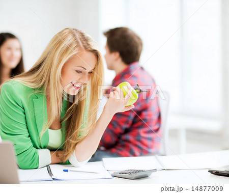 smiling student girl eating apple at school 14877009