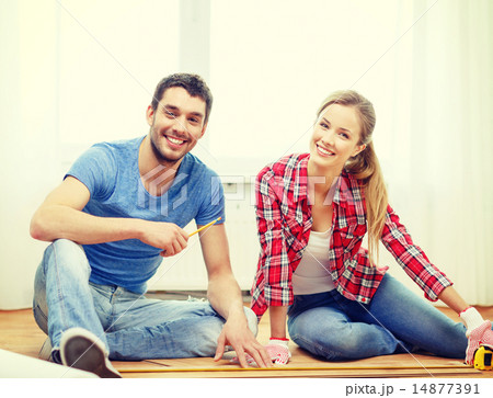 smiling couple measuring wood flooring 14877391
