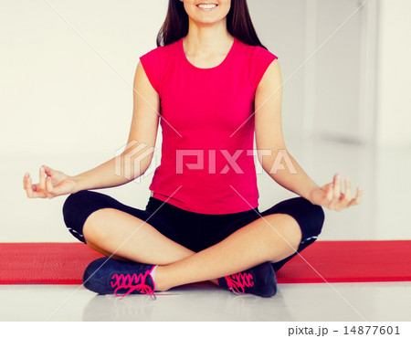 girl sitting in lotus position and meditating 14877601