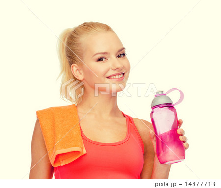 smiling sporty woman with water bottle and towel 14877713