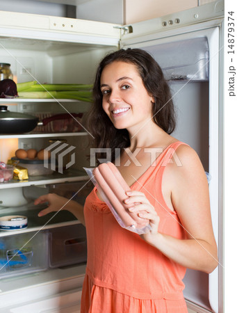 Woman taking sausages from fridge 14879374