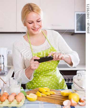 Girl with smartphone at kitchen Girl with smartphone at kitchen 14879571