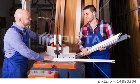 Two workers working on machine Two workers working on machine 14880204