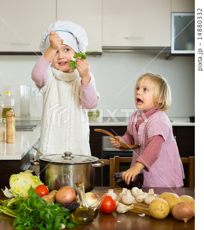 Two little sisters at home kitchen 14880332