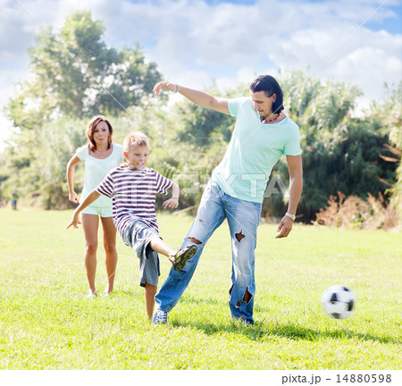 couple with boy playing with soccer ball 14880598